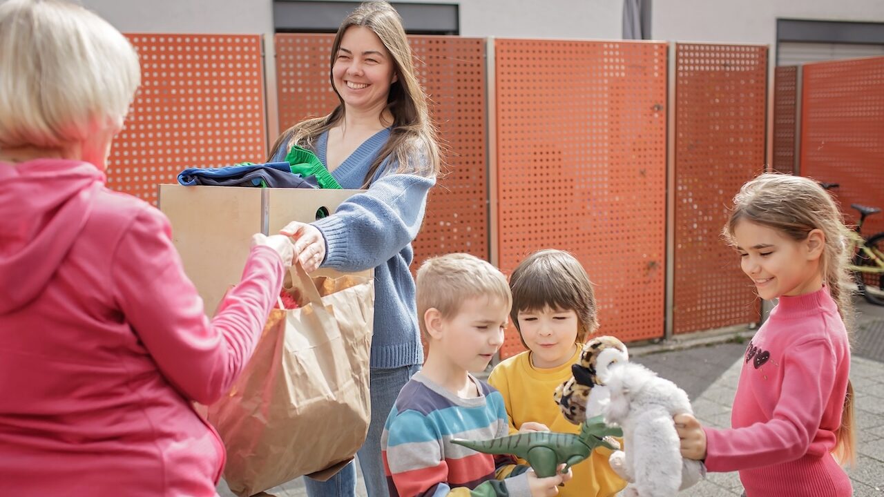 Children donating toys with adults, showing acts of kindness for kids